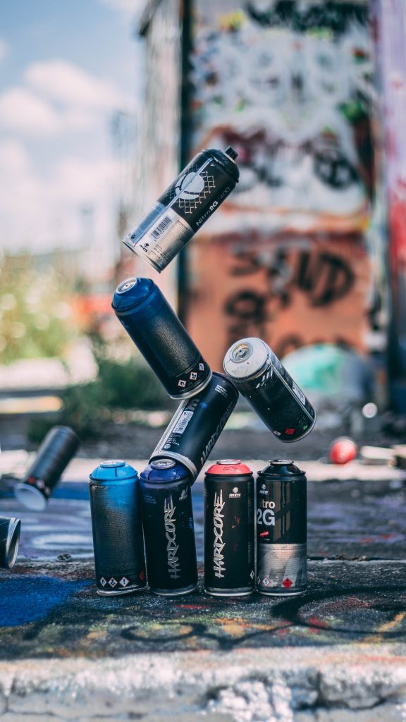 Aerosol spray paint cans that were stacked and are now falling over