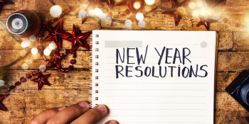 Person writing new year resolutions first person view