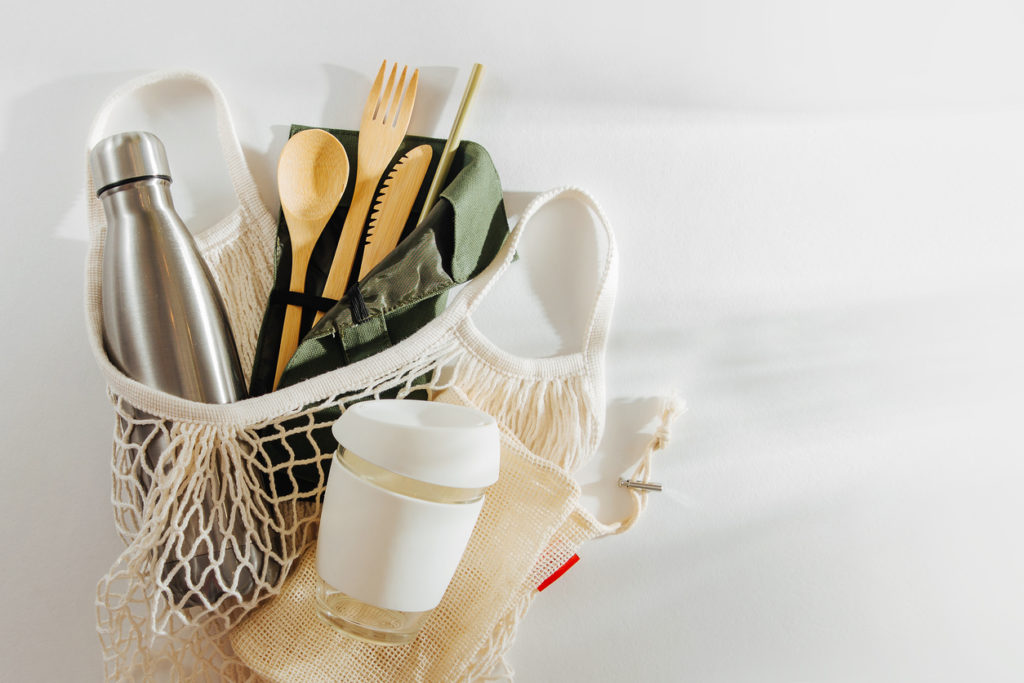 Mesh market bag with bamboo cutlery, reusable coffee mug  and  water bottle. Sustainable lifestyle.  Plastic free concept.