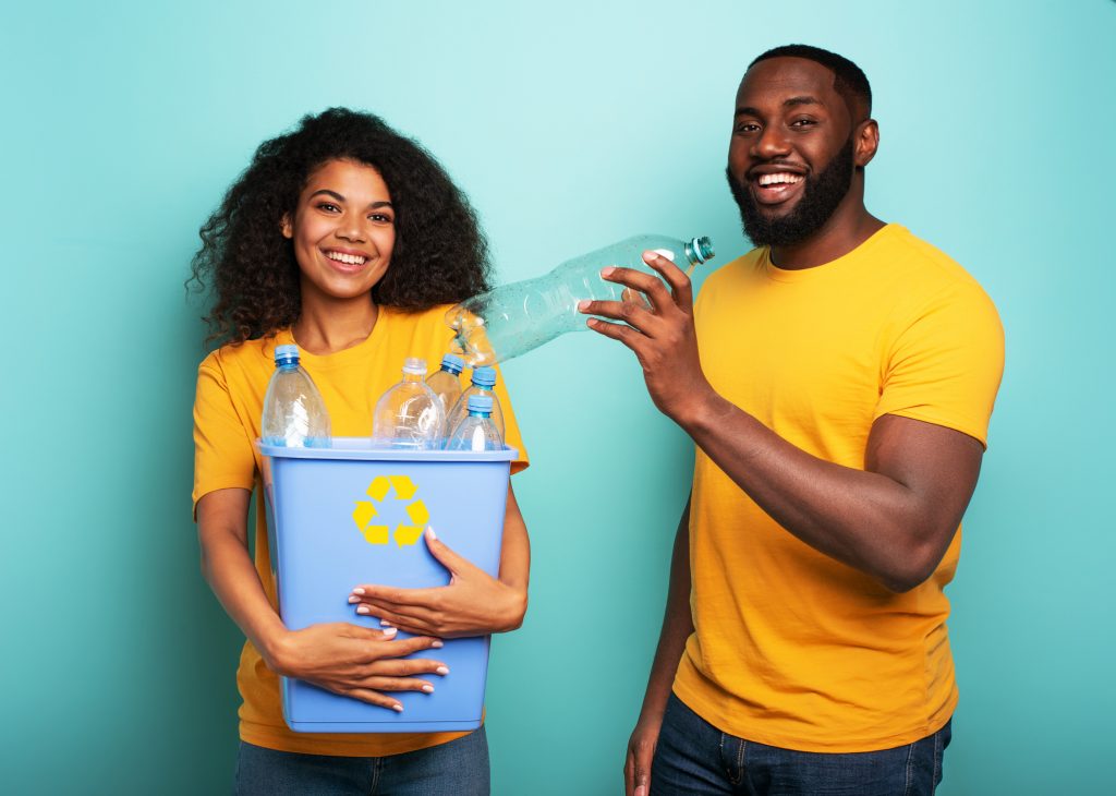 Man and woman recycling plastic bottles