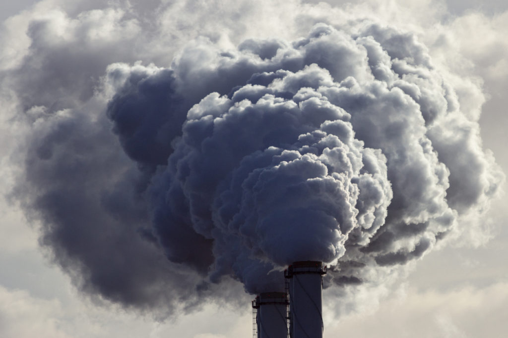 Air pollution from manufacturing plant chimneys.