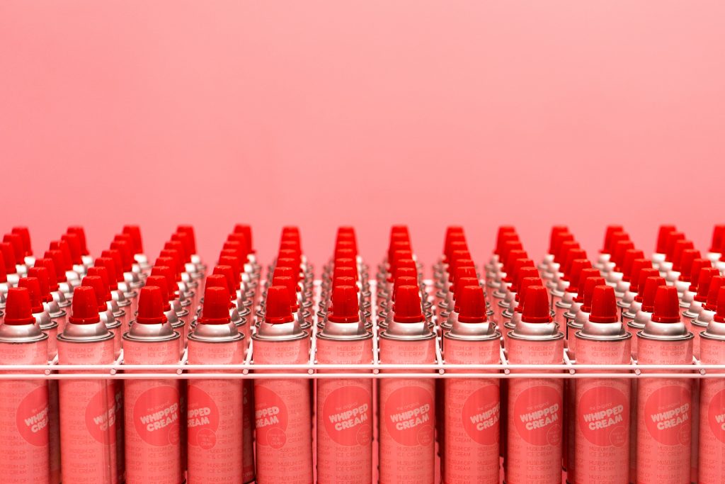 Rows of whipped cream cans lined up with caps on