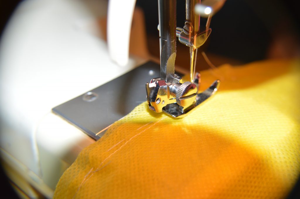 Sewing machine sewing yellow fabric