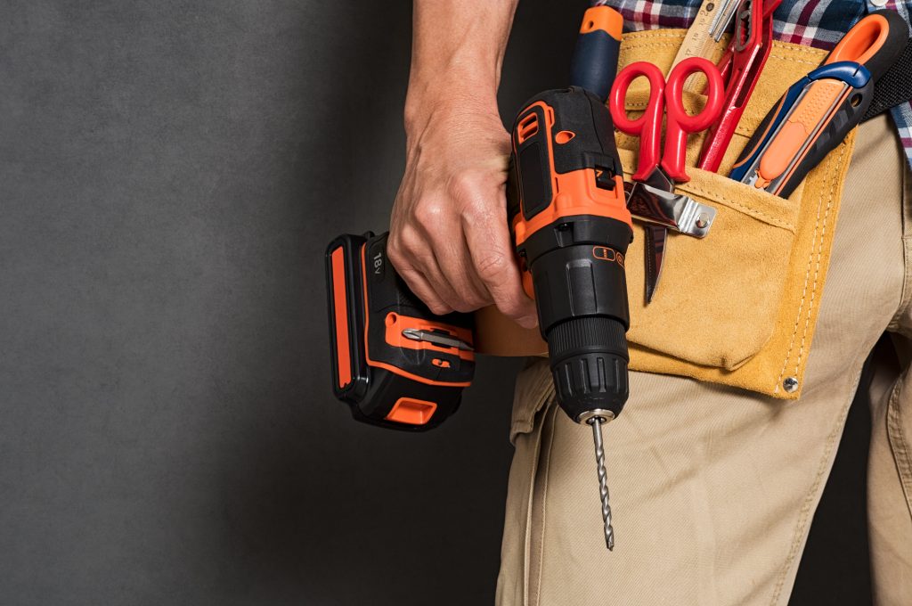 man with toolbelt and power tool