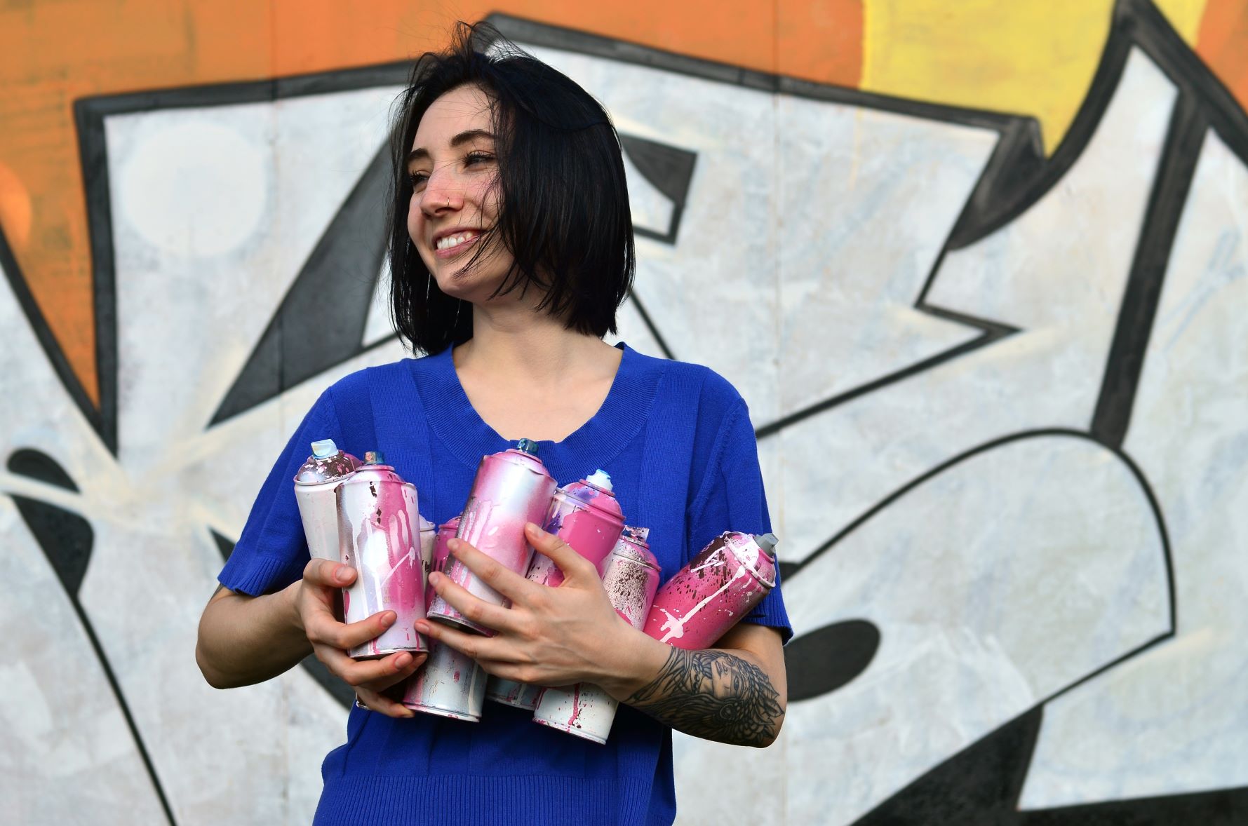 Woman holding aerosol spray paint cans