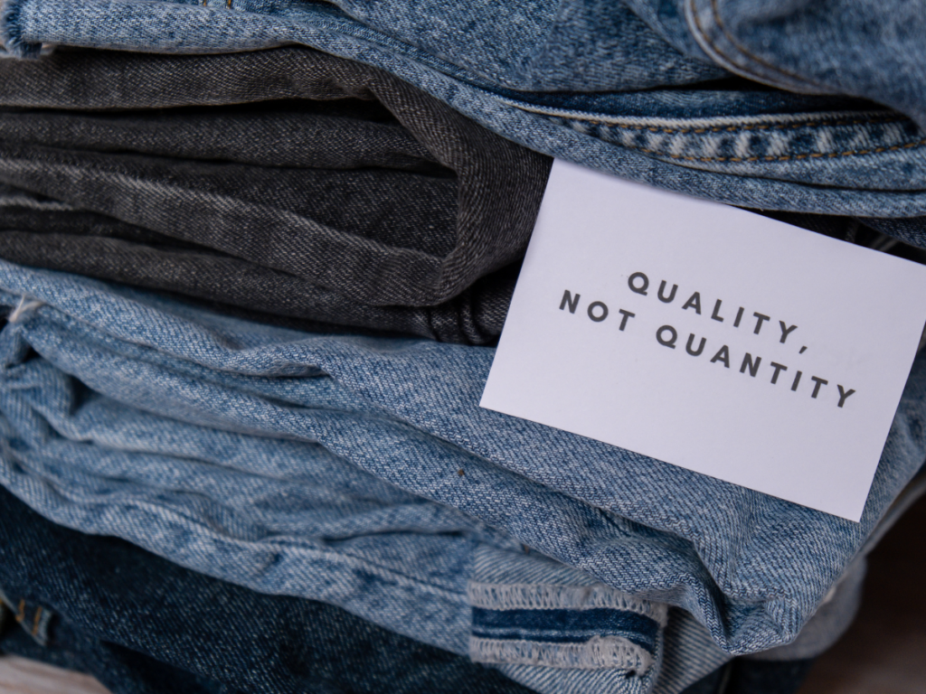 a pile of jeans that has a tag saying "Quality, not quantity"