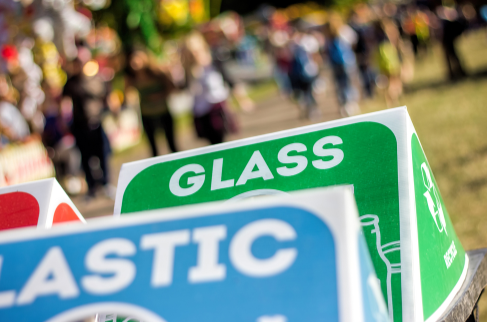 Recycling bins with a festival background