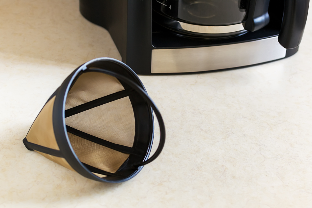 reusable cone coffee filter next to a coffeemaker