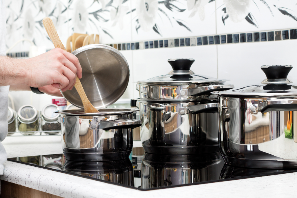 someone stirring a pot while cooking on an induction cooktop 