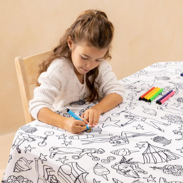 little girl coloring a washable tablecloth