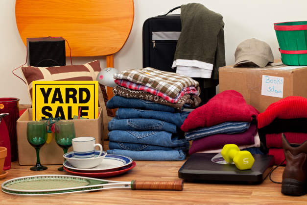 Piles of clothing and household items ready for a yard sale